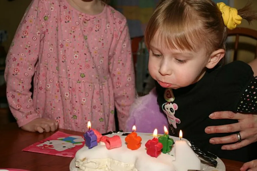 Child blows out candles on birthday cake